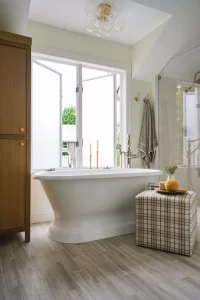 Soaking tub below windows with large bubble chandelier