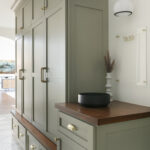 Olive green built in floor to ceiling storage cabinets in an entryway