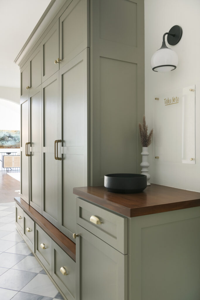 Olive green built in floor to ceiling storage cabinets in an entryway
