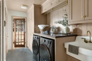 tan cabinetry in laundry room with a farmhouse sink