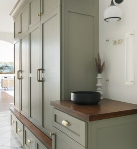 Entryway with built in sage green/dark wood cabinets